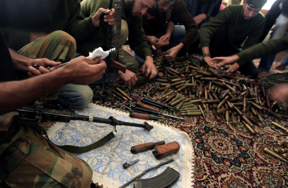 FILE - In this Wednesday, Nov. 14, 2012 file photo, Free Syrian Army fighters clean their weapons and check ammunition at their base on the outskirts of Aleppo, Syria. Syria’s uprising was not destined to be quick. Instead, the largely peaceful protest movement that spread across the nation slowly turned into an armed insurgency and eventually a full-blown civil war. More than 130,000 people have been killed, and more than 2 million more have fled the country. Nearly three years after the crisis began, Syria's government and opposition are set to meet in Geneva this week for the first direct talks aimed at ending the conflict. (AP Photo/ Khalil Hamra, File)