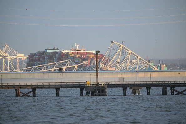 The steel frame of the Francis Scott Key Bridge sits on top of a container ship after it struck the bridge in Baltimore, Maryland, on March 26, 2024. The collapsed sent multiple vehicles and up to 20 people plunging into the harbor below. 