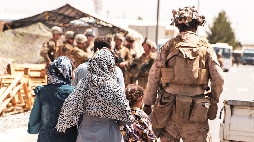A US Marine escorts a family during an evacuation at Hamid Karzai International Airport, Kabul, Afghanistan, 21 August 2021
