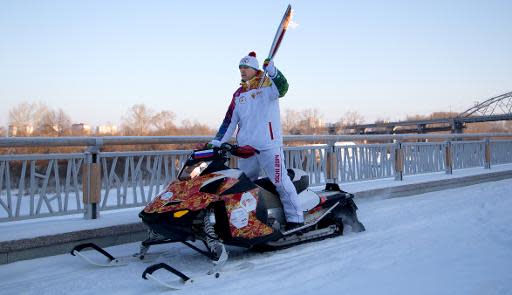 A torchbearer rides with the Olympic torch in the Siberian city of Tyumen, 2144 km east of Moscow, on December 11, 2013