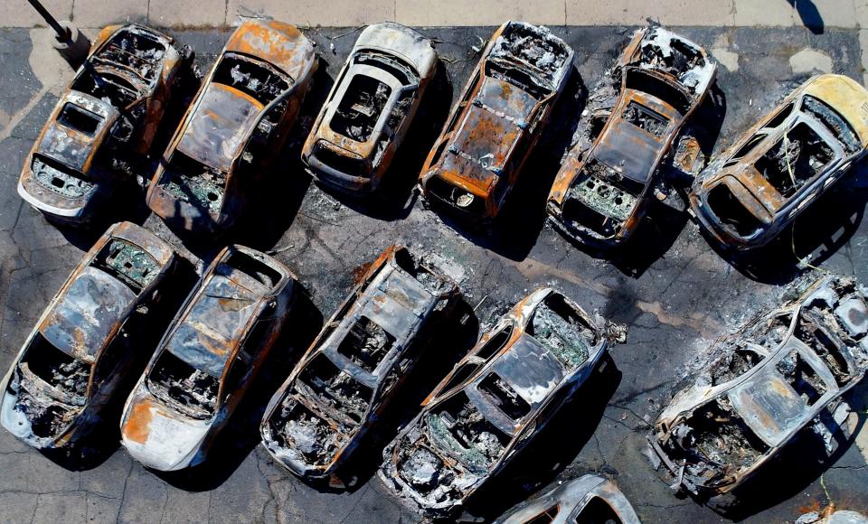 Vehicles sit destroyed after burning at Car Source on Sheridan Road in Kenosha on Sept. 2, 2020.  The destruction came during two consecutive nights of violent protests following the shooting of Jacob Blake.