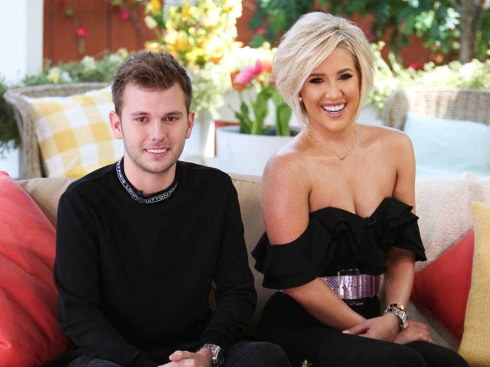 Chase Chrisley and Savannah Chrisley sitting on a couch and smiling