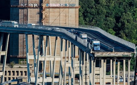 Cars and trucks are left on a section of the collapsed Morandi highway bridge in Genoa - Credit: Nicola Marfisi/AP