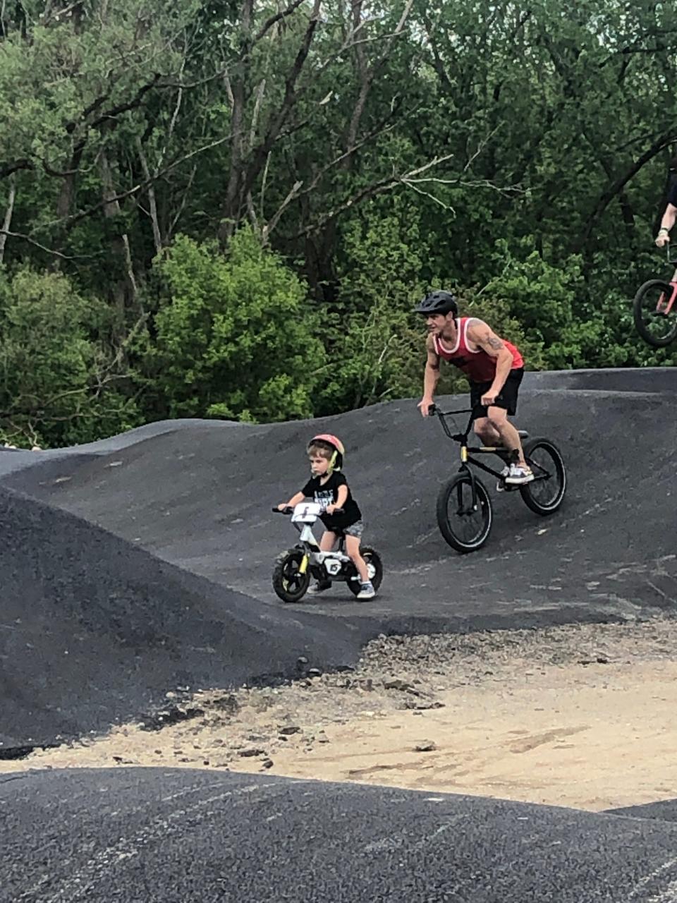 Chad Christian, 38 of Sebring, and his 3-year-old son ride bikes on the new pump track at Memorial Park in Alliance.