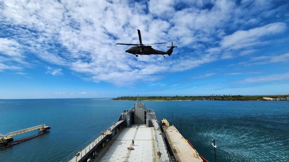 An Army Black Hawk approaches a Logistics Support Vessel to pick up a dummy 