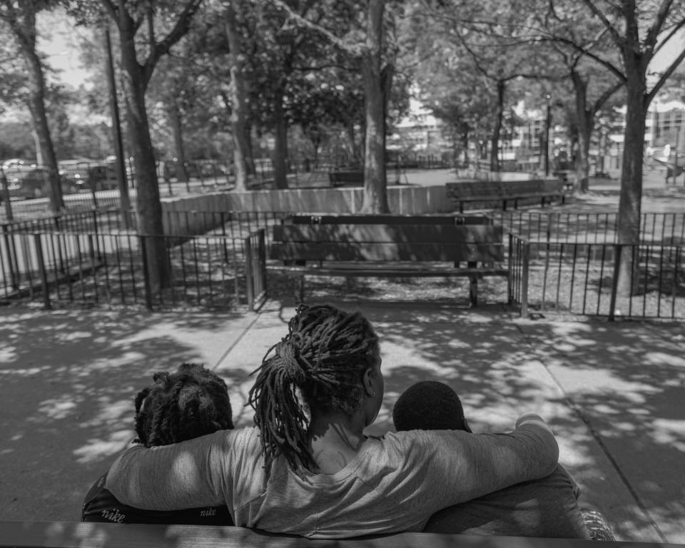 Ronisha and her sons sitting at a park near her their home (Stephanie Mei-Ling for NBC News and ProPublica)