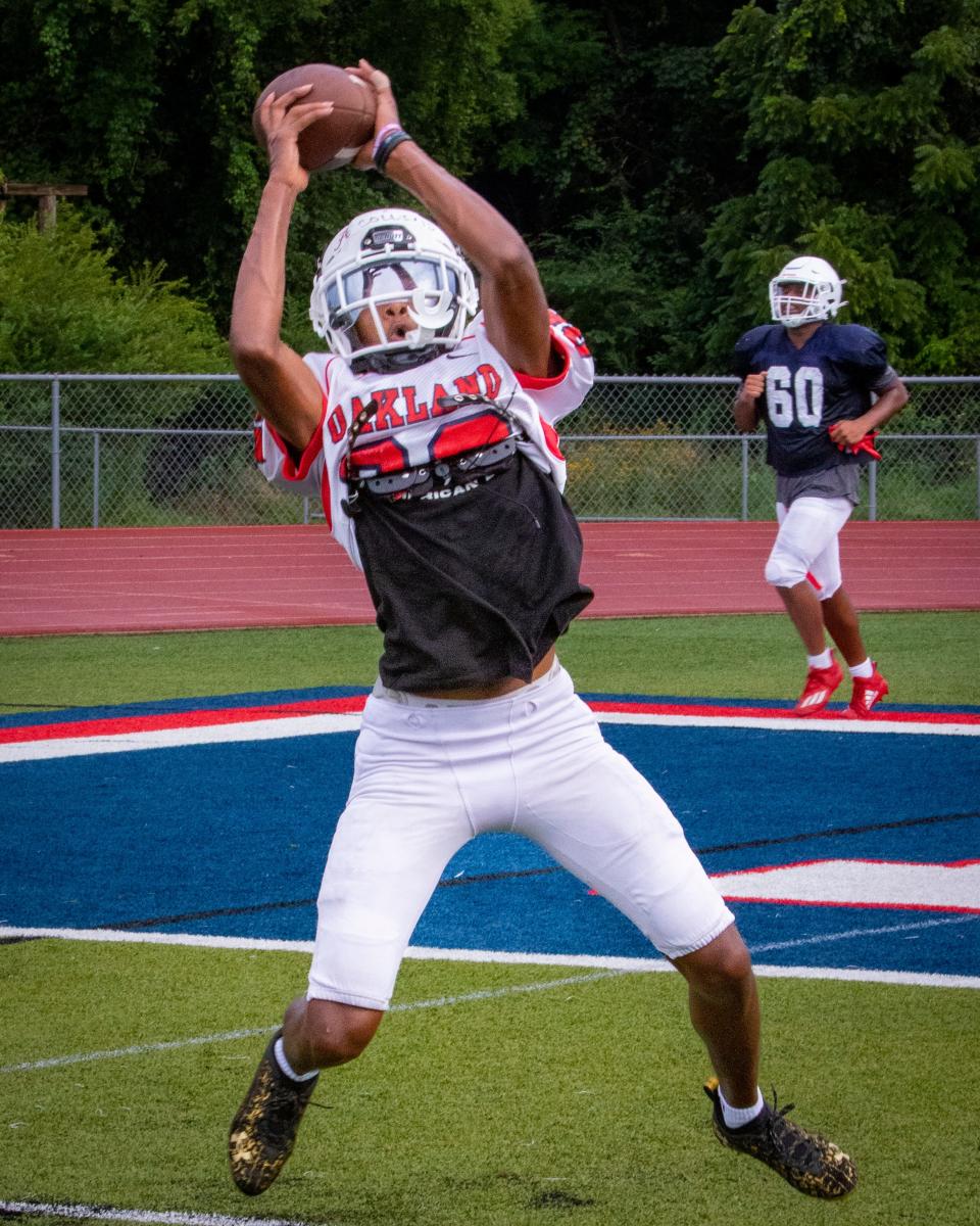 Oakland senior Jeremiah Collins hauls in a pass during Monday's practice.