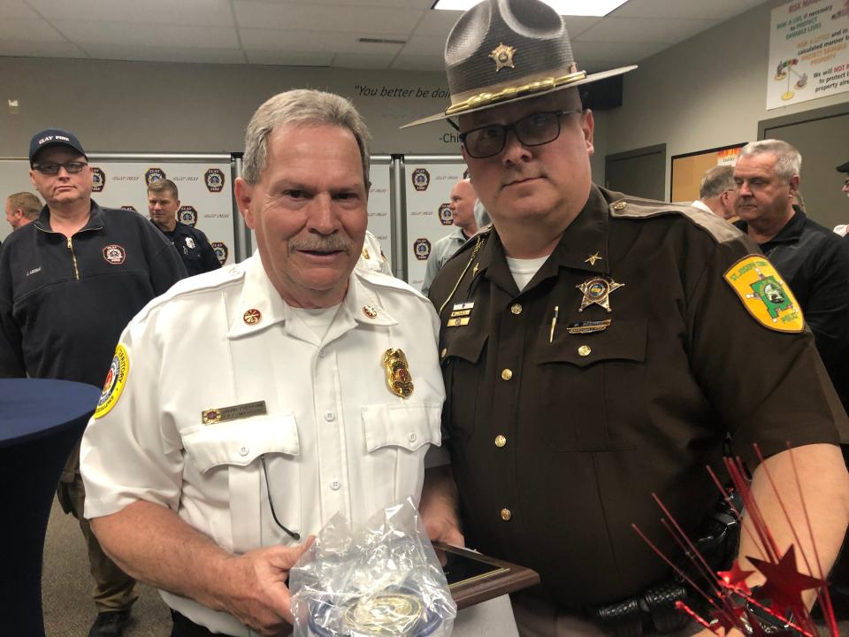 Clay Assistant Fire Chief — Fire Marshal Dave Cherrone receives a service recognition award from Sheriff William Redman. Cherrone recently retired after 52 years with Clay Fire Territory.