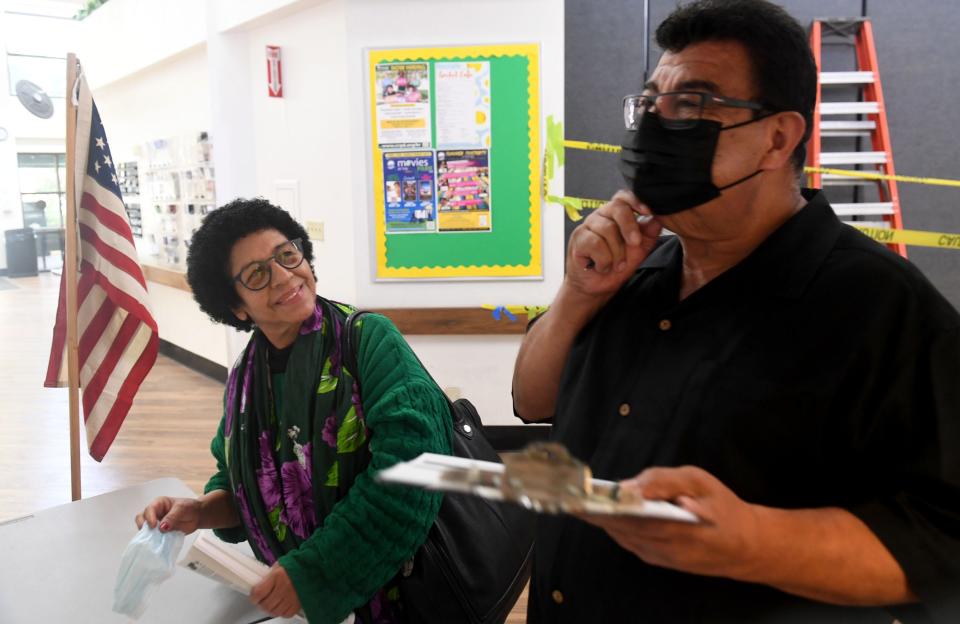 Cecilia Duenas looks at her husband Ernesto Duenas as he fills paperwork in order to vote at the Goebel Adult Community Center in Thousand Oaks on Tuesday, June 7, 2022.