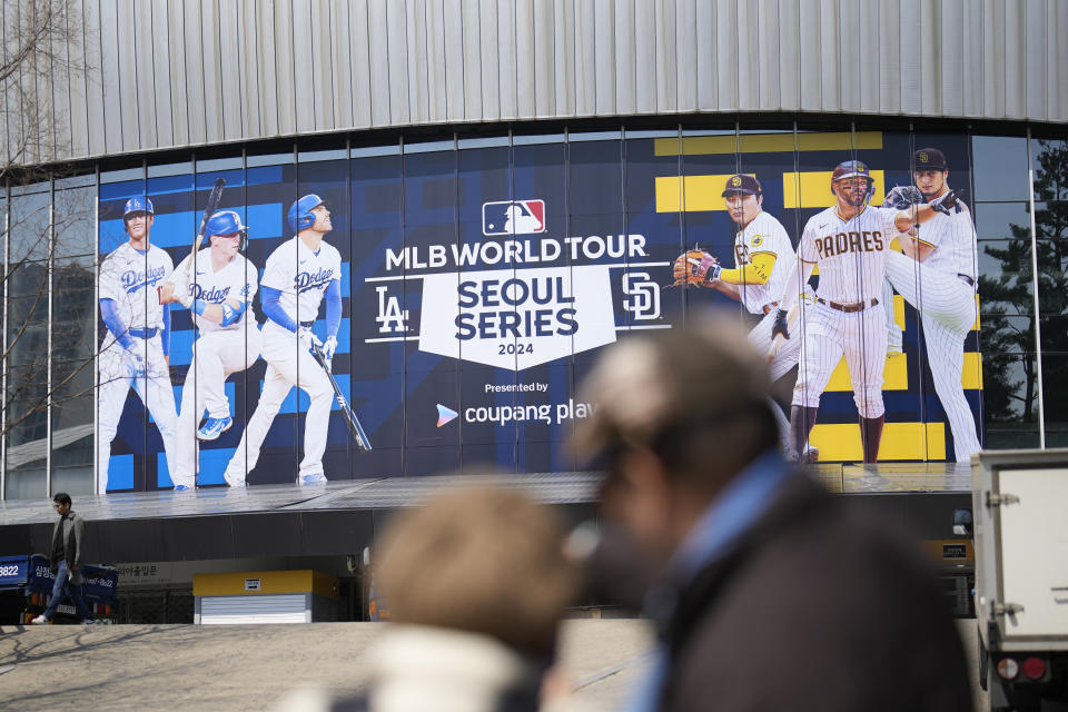 People try to take pictures outside of the Gocheok Sky Dome is seen in Seoul, South Korea, Wednesday, March 13, 2024. The Gocheok Sky Dome will be the stadium for the two games of the MLB World Tour Seoul Series between Los Angeles Dodgers and San Diego Padres on March 20 and 21. (AP Photo/Lee Jin-man)