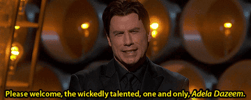 John Travolta on stage at an awards show, mistakenly says "Adele Dazeem" instead of Idina Menzel