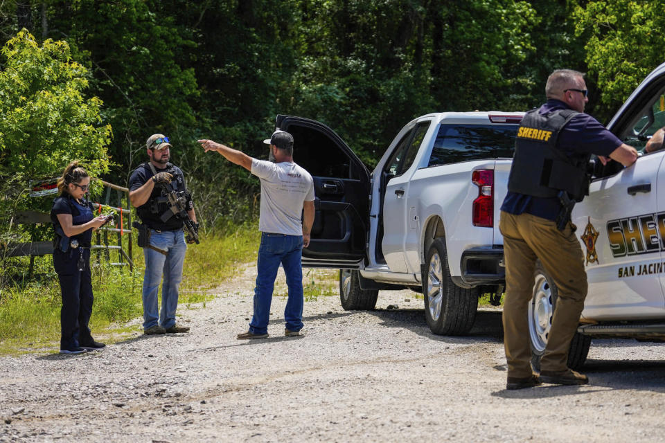 Local resident Bubba Coburn speaks with authorities as they search wooded areas, in Cleveland, Texas, Monday, May 1, 2023, for a suspect who fatally shot five neighbors several days earlier. (Raquel Natalicchio/Houston Chronicle via AP)