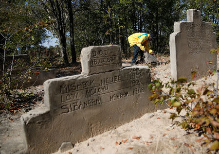 Pastor John Moyo, 76, tends to the graves of people killed during a government crackdown on rebels loyal to Robert Mugabe's political rival Joshua Nkomo in the mid-1980s, site near Tsholotsho, Zimbabwe, June 23, 2018. Picture taken June 23, 2018. REUTERS/Philimon Bulawayo