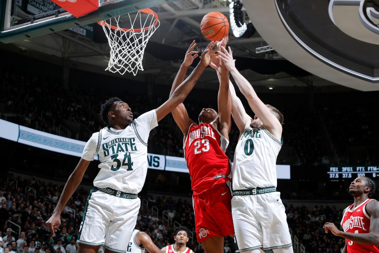 Ohio State forward Zed Key (23) reaches for a rebound against Michigan State forwards Xavier Booker (34) and Jaxon Kohler (0) during the first half at Breslin Center in East Lansing on Sunday, Feb. 25, 2024.
