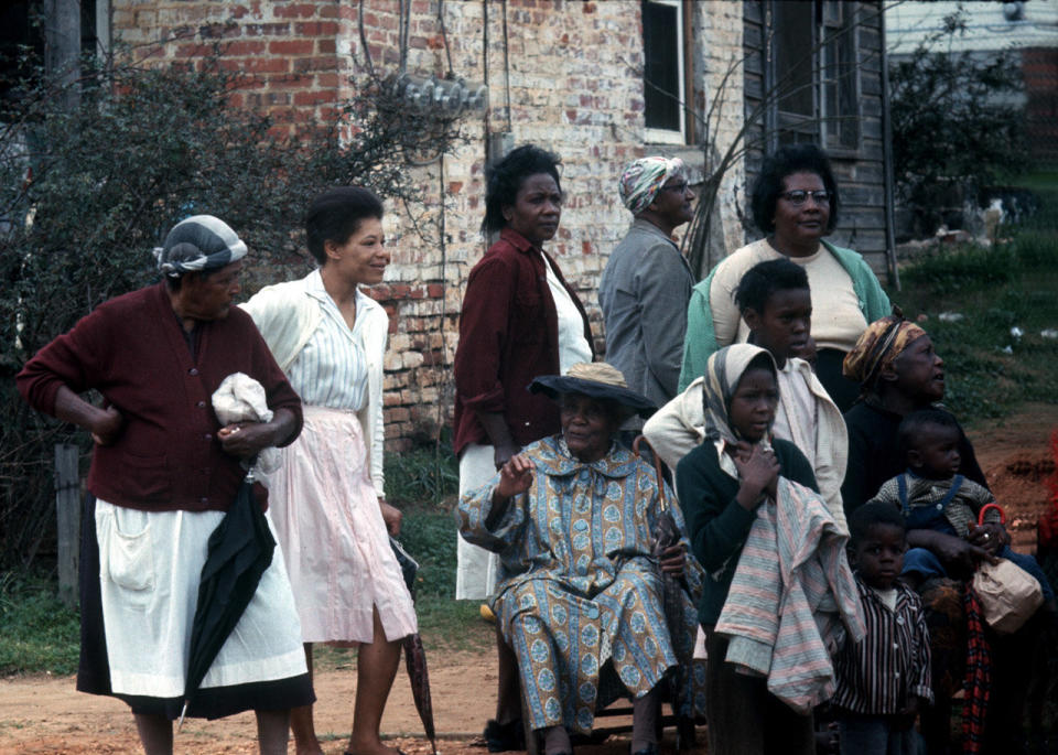 Three generations of women with children watching civil rights marchers, 1965.