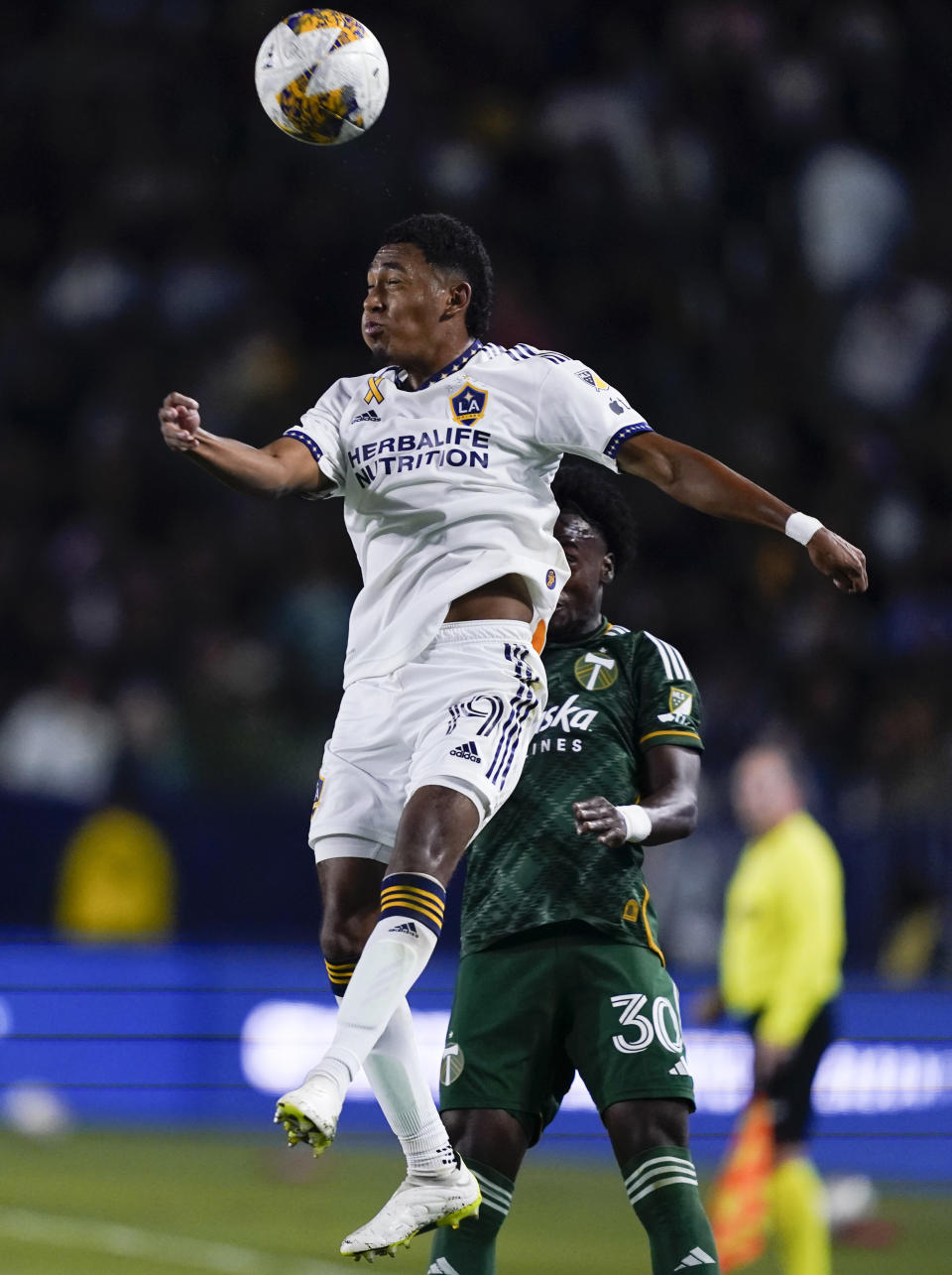 LA Galaxy defender Mauricio Cuevas (19) jumps for a head ball next to Portland Timbers midfielder Santiago Moreno during the first half of an MLS soccer match Saturday, Sept. 30, 2023, in Carson, Calif. (AP Photo/Ryan Sun)