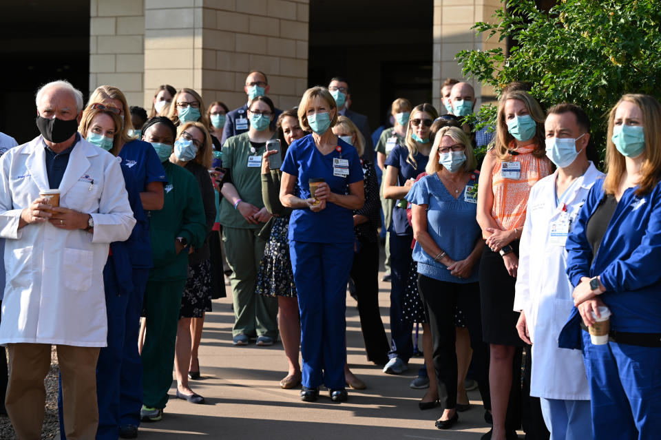 Frontline workers at the Medical Center of Aurora in Colorado stand in front of the hospital.