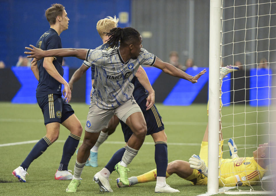 CF Montreal's Chinonso Offor, front left, scores against Philadelphia Union goalkeeper Joe Bendik, right, during second-half MLS soccer match action in Montreal, Saturday, March 18, 2023. (Graham Hughes/The Canadian Press via AP)