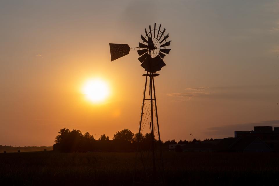 The sun sets behind a windmill off US-75 highway north of Holton, in an area that a recent study predicts by 2053 will become part of an "extreme heat belt."