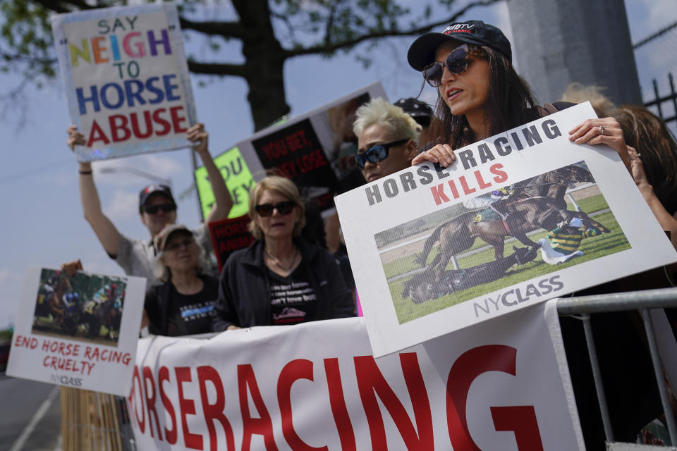 Protestors stand outside an entrance gate with signs decrying the sport of horse racing ahead of the Belmont Stakes horse race, Saturday, June 10, 2023, at Belmont Park in Elmont, N.Y. (AP Photo/John Minchillo)