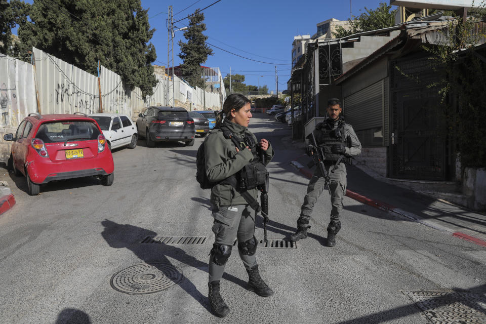 Israeli border police officers stand guard at the scene of a stabbing attack in east Jerusalem, Wednesday, Dec. 8, 2021. An Israeli woman was stabbed and lightly wounded in Sheikh Jarrah neighborhood in east Jerusalem on Wednesday. The suspect, a Palestinian female minor, fled the scene and was later arrested inside a nearby school, police said. (AP Photo/Mahmoud Illean)