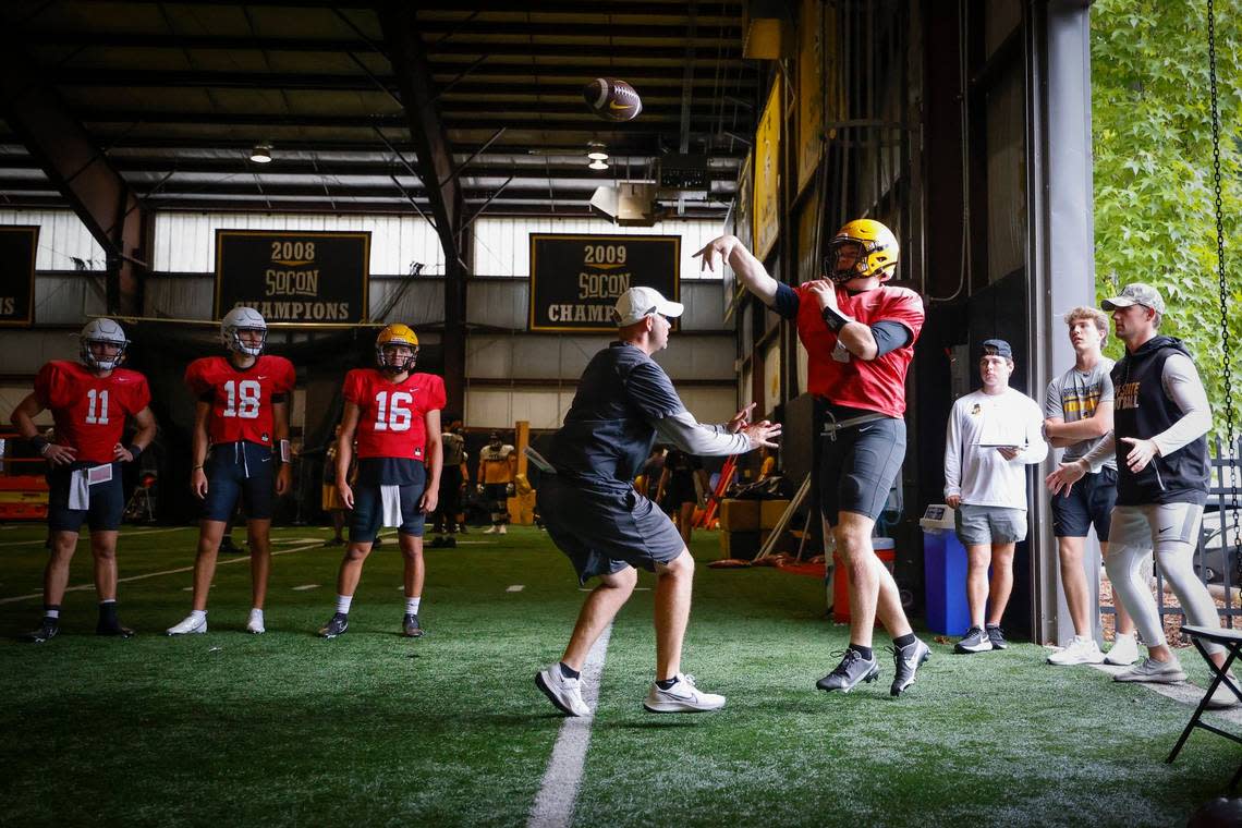 Offensive coordinator/quarterbacks coach Kevin Barbary, center, runs a drill with quarterback Chase Brice (7) during an indoor practice in Boone, N.C., Tuesday, Aug. 30, 2022. The Appalachian State Mountaineers football team is preparing to host UNC this weekend.