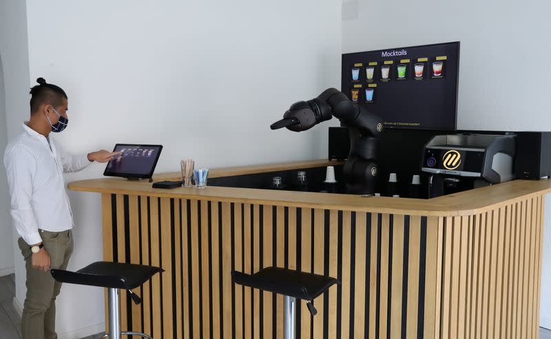 An employee taps a display to order a coffee at the Barney Barista Bar in Zurich