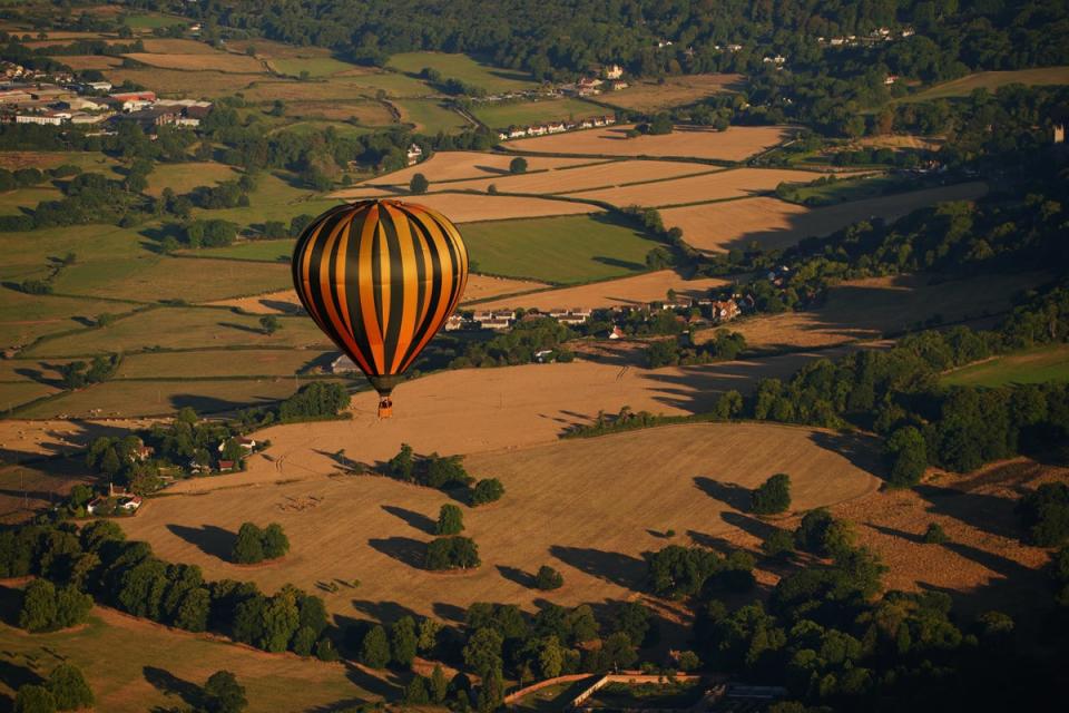 A balloon flies over fields which have turned brown and dried out in the prolonged spell of dry weather (Ben Birchall/PA) (PA Wire)