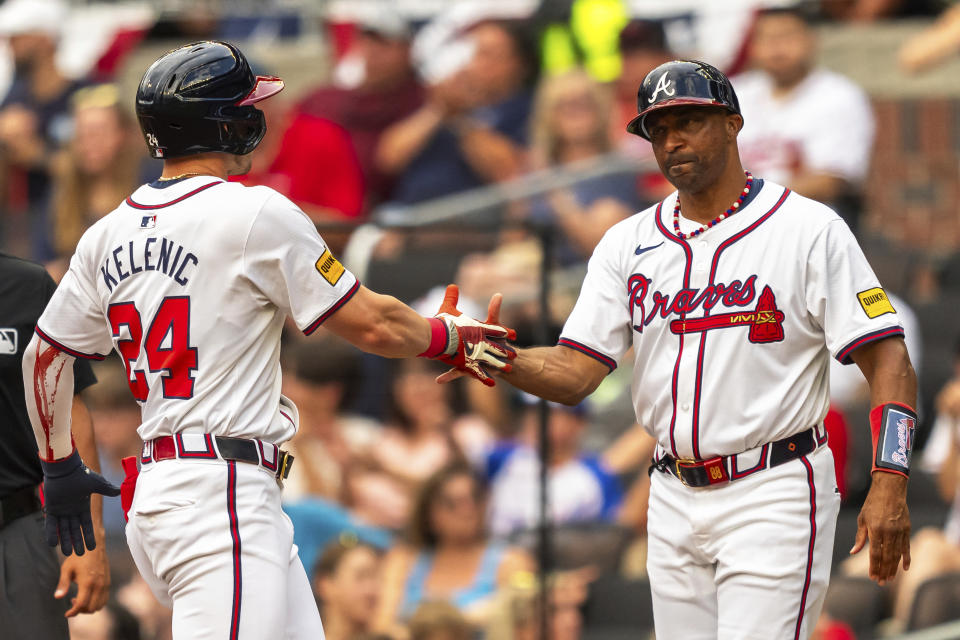 Atlanta Braves' Jarred Kelenic (24) slaps hands with first base coach Tom Goodwin (88) during the first inning of a baseball game against the San Francisco Giants, Thursday, July 4, 2024, in Atlanta. (AP Photo/Jason Allen)