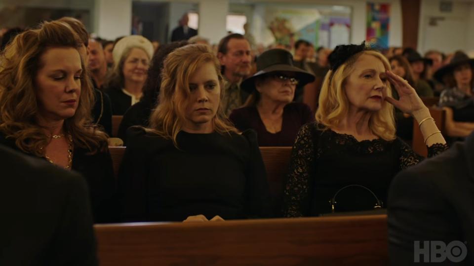 Amy Adams and Patricia Clarkson sit in a crowded church attending someone's funeral