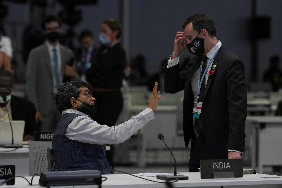 Archie Young, right, UK Lead Climate Negotiator speaks to a member of the Indian delegation as they attend a stocktaking plenary session at the COP26 U.N. Climate Summit, in Glasgow, Scotland, Saturday, Nov. 13, 2021. Going into overtime, negotiators at U.N. climate talks in Glasgow are still trying to find common ground on phasing out coal, when nations need to update their emission-cutting pledges and, especially, on money. (AP Photo/Alastair Grant)
