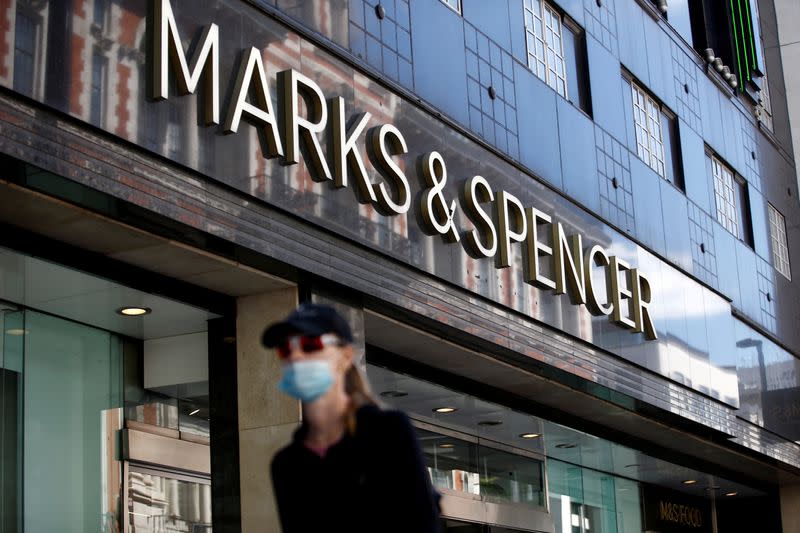 FILE PHOTO: A woman walks past a M&S store at Oxford Street in London, Britain