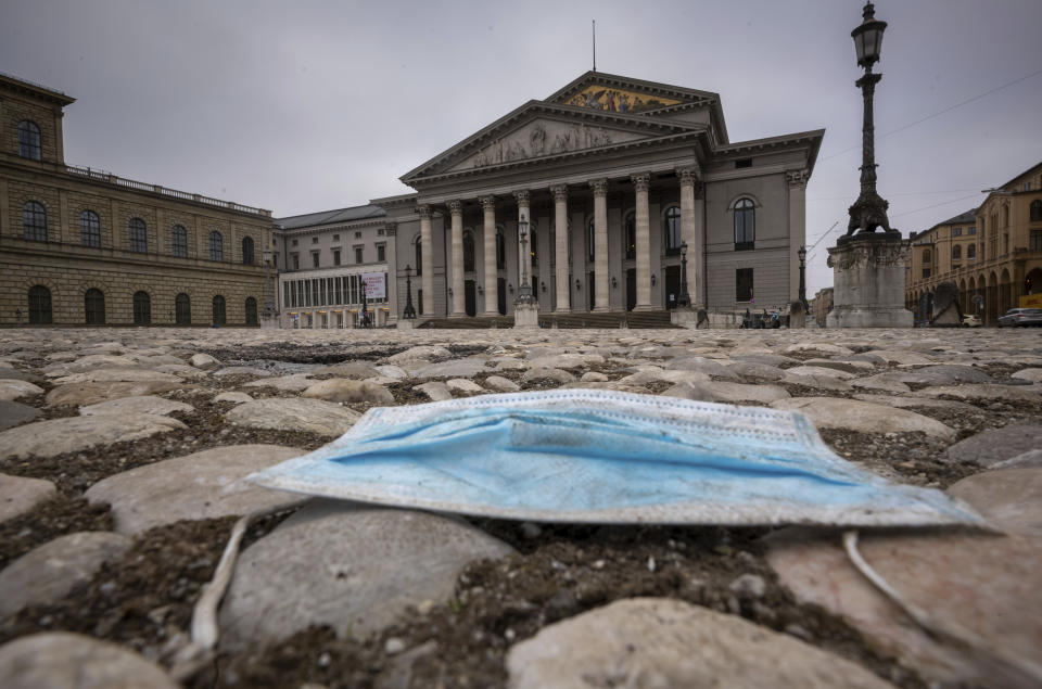 A blue mouth-nose protector lies on the pavement in front of the Bavarian State Opera in the centre of the city of Munich, Germany, during the lockdown on Tuesday, Jan. 5, 2020. (Peter Kneffel/dpa via AP)