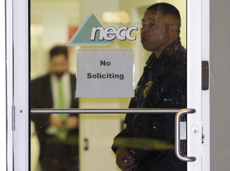 A Food and Drug Administration Agent stands at the doorway of New England Compounding Center in Framingham, Mass., Tuesday, Oct. 16, 2012, as investigators work inside. The company's steroid medication has been linked to a deadly meningitis outbreak. FDA spokesman Steven Immergut says the visit is part of the investigation into the outbreak, which has killed at least 15 people and sickened more than 200 others in 15 states. (AP Photo/Bill Sikes)