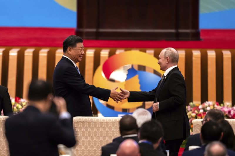 <cite>2023年10月18日，中國國家主席習近平和俄羅斯總統普京在北京人民大會堂的「一帶一路」論壇上握手。（美聯社）</cite>