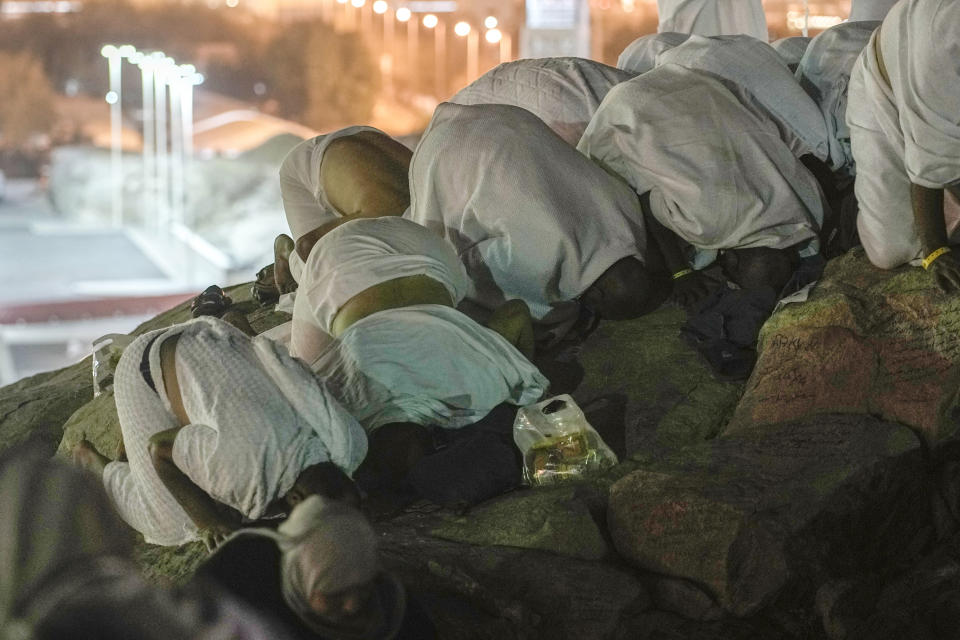 Muslim pilgrims pray on the rocky hill known as the Mountain of Mercy, on the Plain of Arafat, during the annual Hajj pilgrimage, near the holy city of Mecca, Saudi Arabia, Tuesday, June 27, 2023. Around two million pilgrims are converging on Saudi Arabia's holy city of Mecca for the largest Hajj since the coronavirus pandemic severely curtailed access to one of Islam's five pillars. (AP Photo/Amr Nabil)