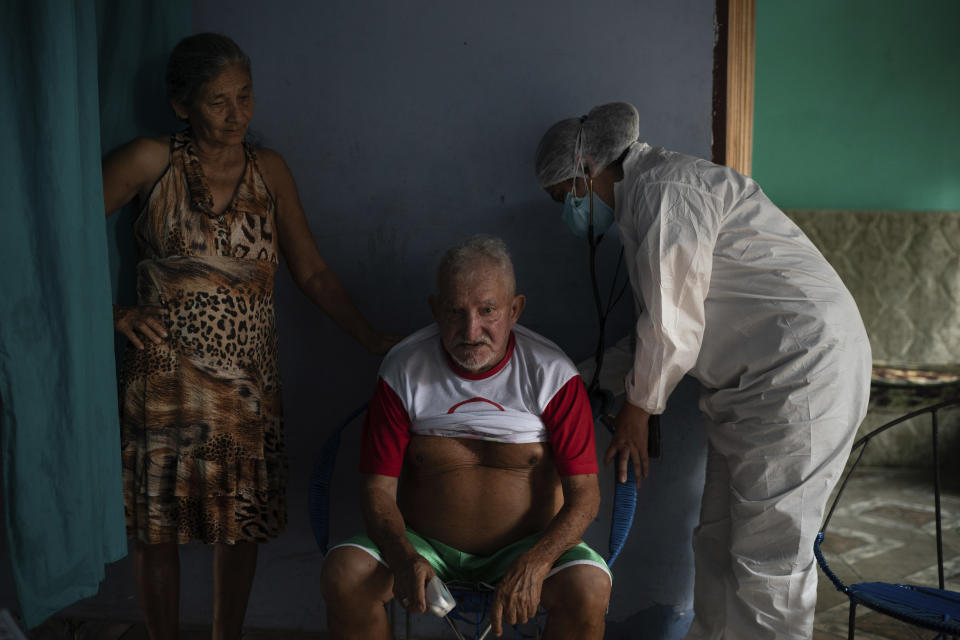 Francisco de Oliveira, 77, takes a deep breath while Doctor Dayanne Araujo listens to his lungs in Manacapuru, Amazonas state, Brazil, Tuesday, June 2, 2020. Oliveira is waiting for his COVID-19 test results after feeling weakness, difficulty breathing and other symptoms. (AP Photo/Felipe Dana)