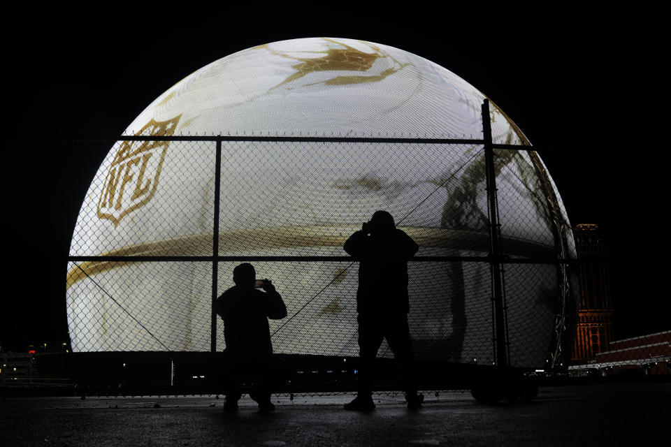 People take photos of the Sphere featuring an ad for the NFL on the Sphere Tuesday, Feb. 6, 2024 in Las Vegas. The Kansas City Chiefs are scheduled to play the San Francisco 49ers in Super Bowl 58 Sunday. (AP Photo/Charlie Riedel)