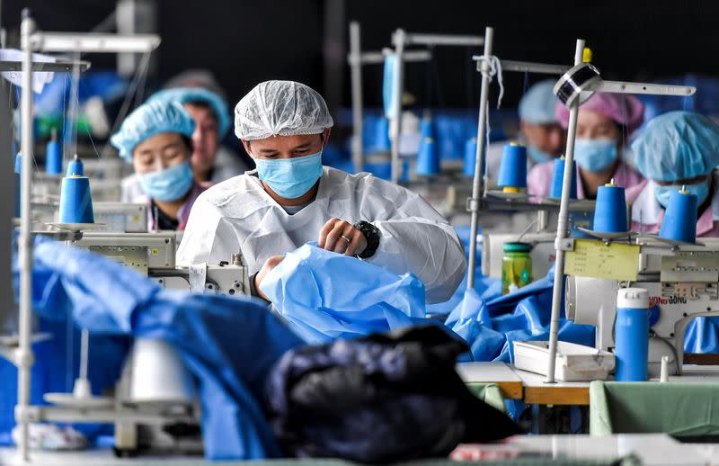 Workers make protective suits at a factory of a medical equipment maker in Urumqi, Xinjiang