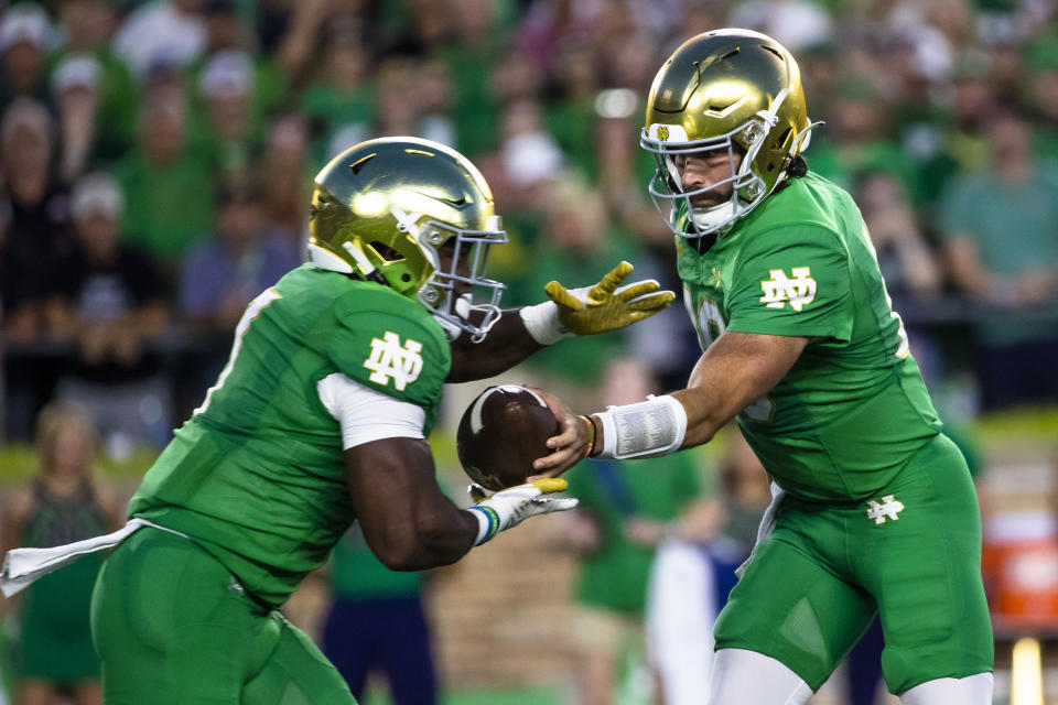 Notre Dame's Sam Hartman (10) hands off to Audric Estimé (7) during the first half of an NCAA college football game against Ohio State on Saturday, Sept. 23, 2023, in South Bend, Ind. (AP Photo/Michael Caterina)