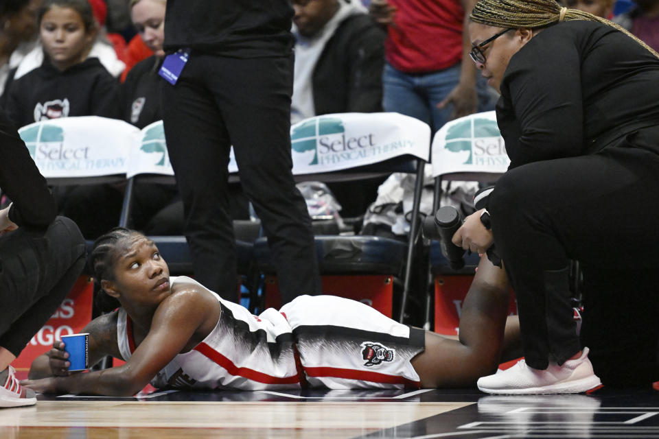 North Carolina State's Diamond Johnson, left, has her leg tended to by athletic trainer Brittany Blunt, right, during the second half of an NCAA college basketball game against Connecticut, Sunday, Nov. 20, 2022, in Hartford, Conn. (AP Photo/Jessica Hill)