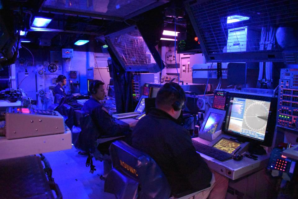 Sailors work in the combat information center on the USS Gravely.