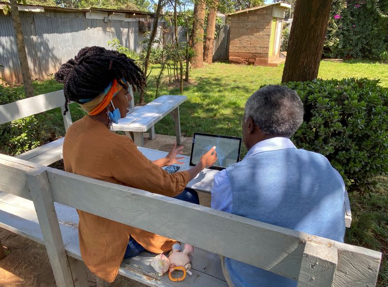 Chao Tayiana, a digital historian, and her grandfather Daniel Sindiyo look at the reconstructed 3D models of the detention camps, during a Reuters interview in Ngong