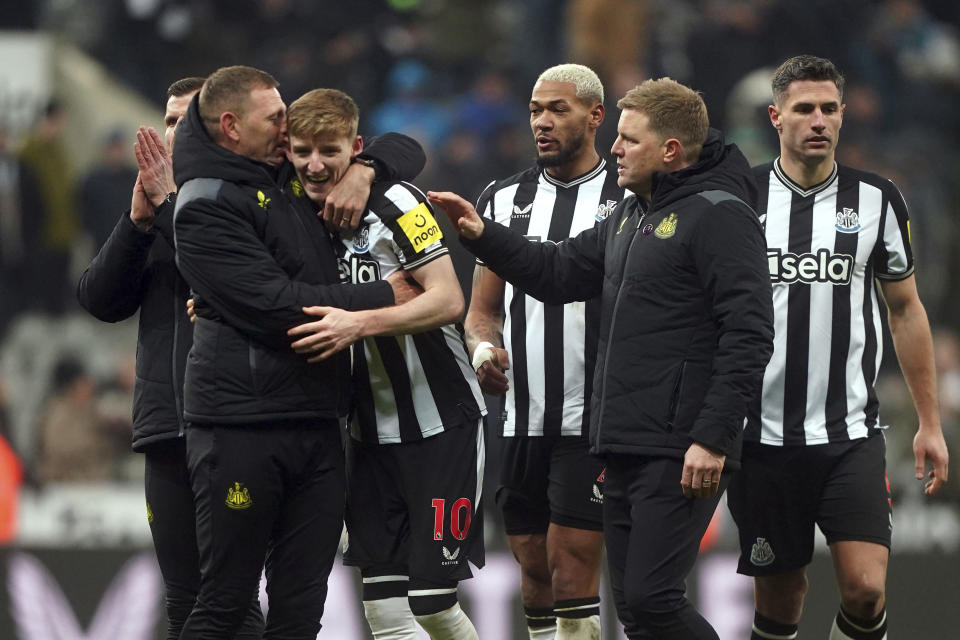 Newcastle United's Anthony Gordon, center, is congratulated by manager Eddie Howe and staff following the team's victory after the final whistle of the English Premier League soccer match between Newcastle United and Manchester United at St. James' Park, Newcastle, England, Saturday, Dec. 2, 2023. (Owen Humphreys/PA via AP)