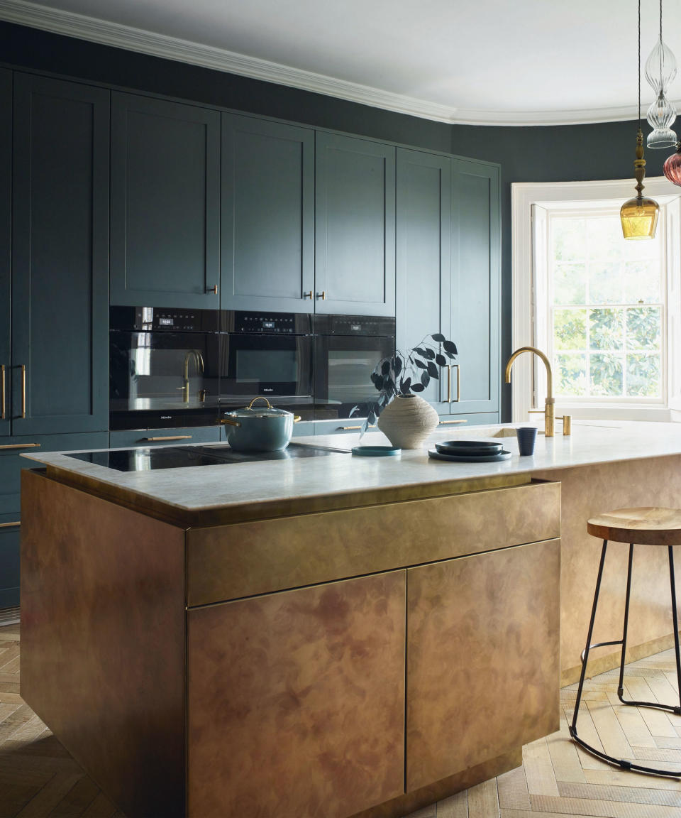 Modern kitchen with brass kitchen island, dark blue painted cabinetry