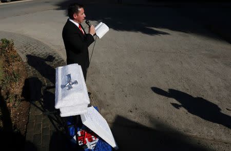 A demonstrator rejecting a bill of the government to legalise abortion in certain cases reads from the Bible next to a coffin outside of the Chile's congress, in Valparaiso, Chile July 20, 2017. REUTERS/Rodrigo Garrido