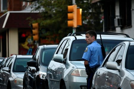 A police officer stands near vehicles during an active shooter situation in Philadelphia