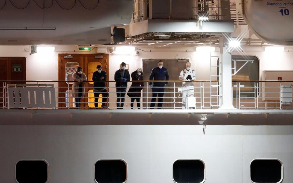 Passengers on the deck of the Diamond Princess wave to other passengers, believed to be British citizens, as they leave the coronavirus-hit cruise ship Diamond Princess - Reuters