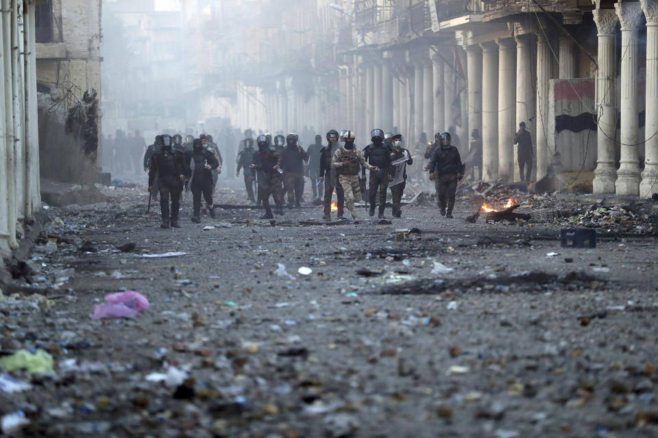 Riot police try to disperse anti-government protesters during clashes in Baghdad, Iraq, Saturday, Nov. 23, 2019. (AP Photo/Hadi Mizban)