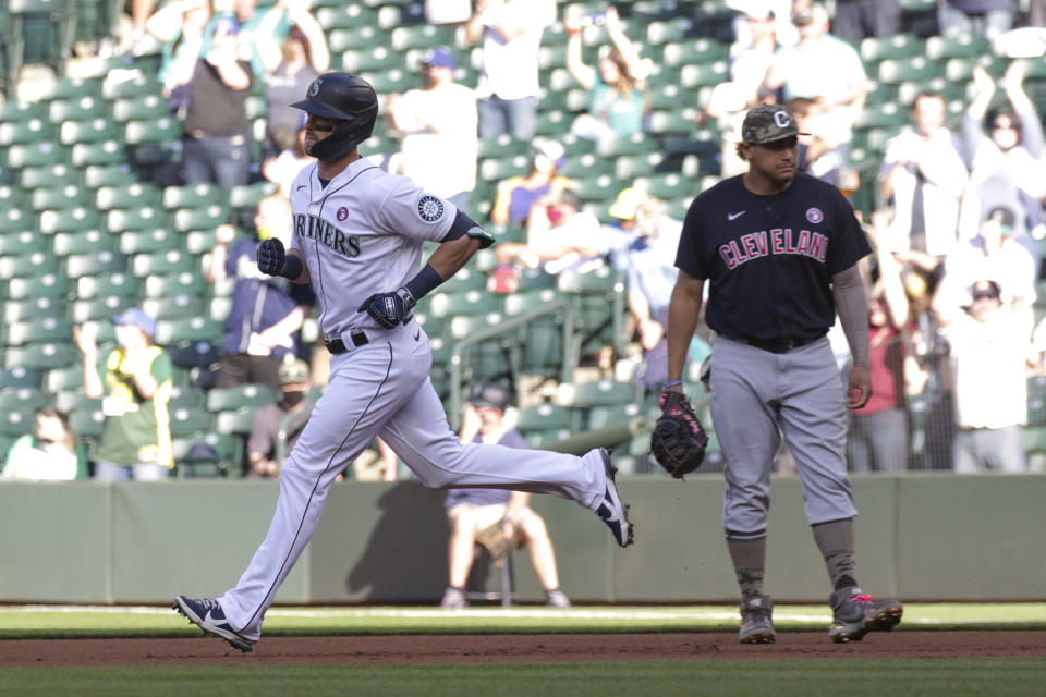 Seattle Mariners' Mitch Haniger runs past Cleveland Indians first baseman Josh Naylor following a solo home run during the first inning of a baseball game Saturday, May 15, 2021, in Seattle. (AP Photo/Jason Redmond)